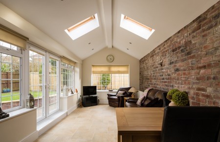 Modern Sunroom or conservatory extending into the garden with a featured brick wall